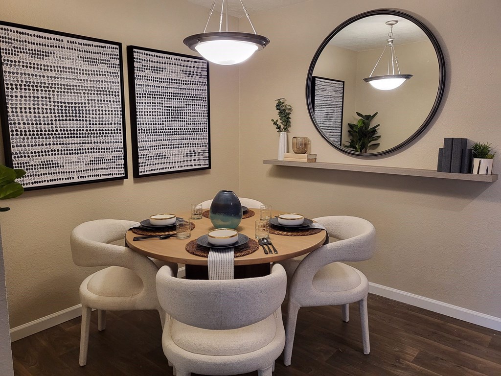 a dining room with a round table and white chairs
